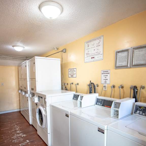 a laundry room with several washes and dryers in it