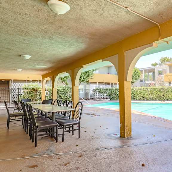 a patio with a swimming pool and a table and chairs