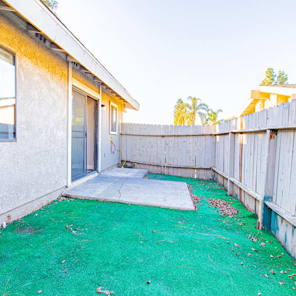 the backyard of a house with a green yard and a fence