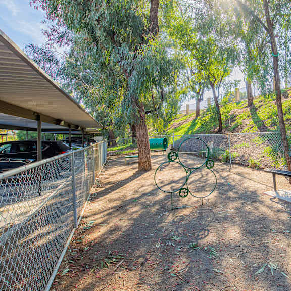 a picnic area with a bench and a chain link fence