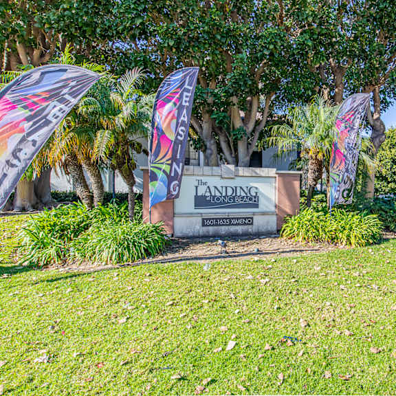 a sign for the harrison school district in front of a sidewalk and some flags