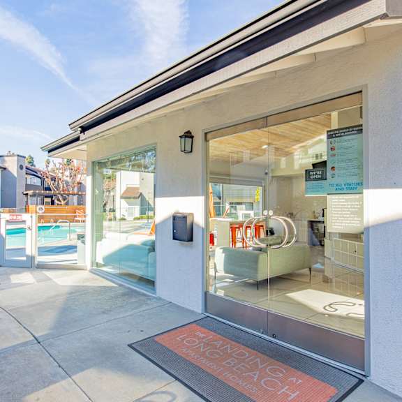 the entrance to a building with glass doors and a swimming pool