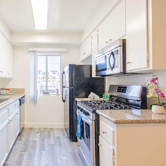 a kitchen with white cabinets and stainless steel appliances and granite counter tops