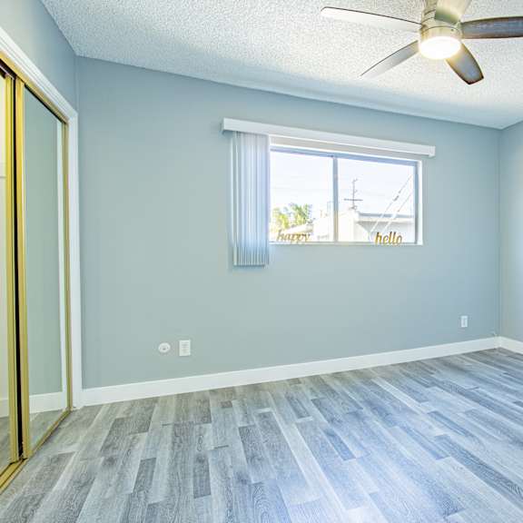 an empty room with a window and a ceiling fan