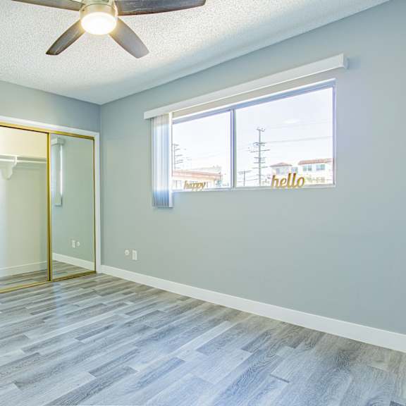 an empty room with a ceiling fan and a window