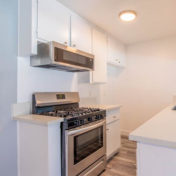 a kitchen with white cabinets and stainless steel appliances