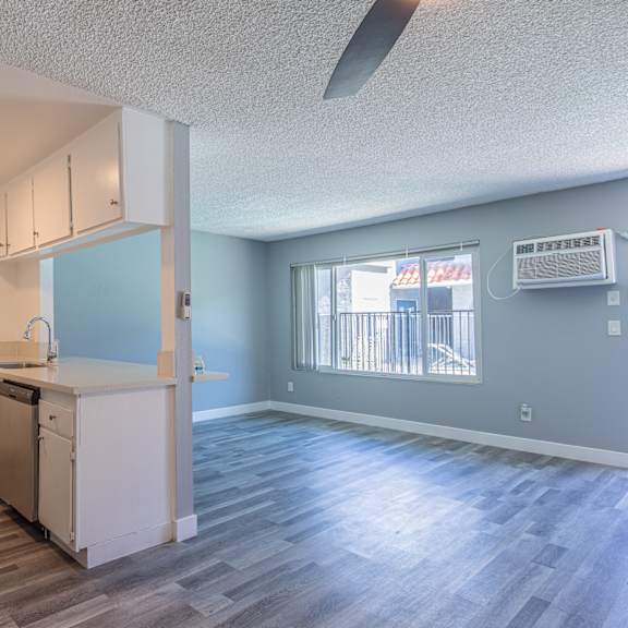 an empty kitchen and living room with a large window