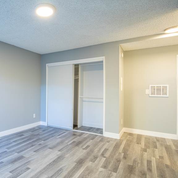 an empty living room with blue walls and a door to a closet