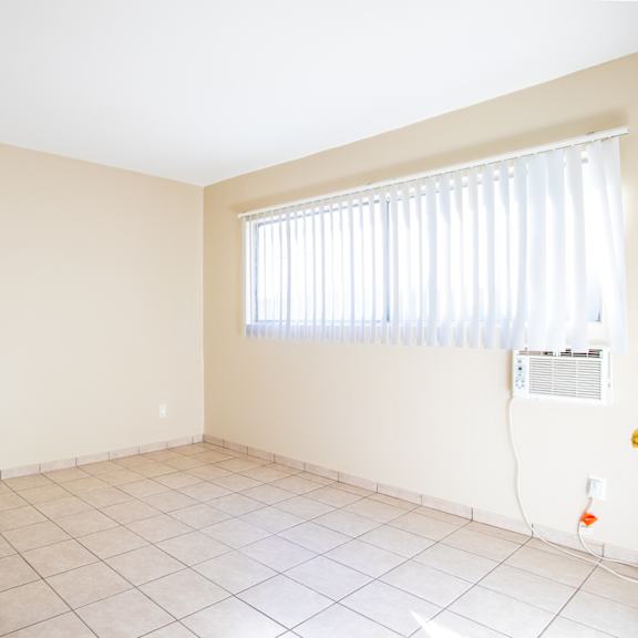 an empty room with a window and a tiled floor