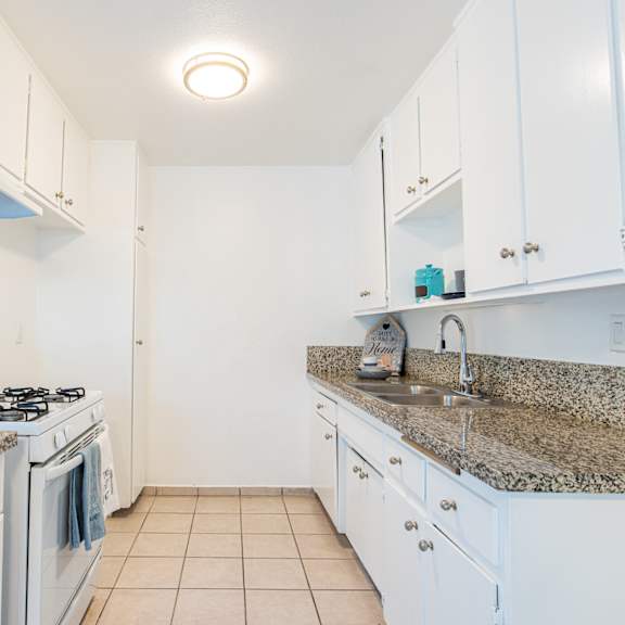 a kitchen with white appliances and granite counter tops