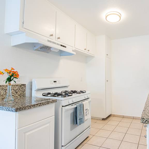 a kitchen with white appliances and granite counter tops