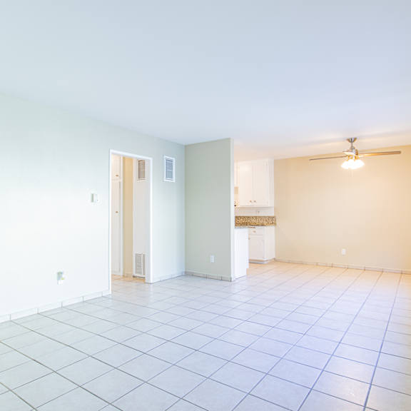 an empty living room with a tile floor