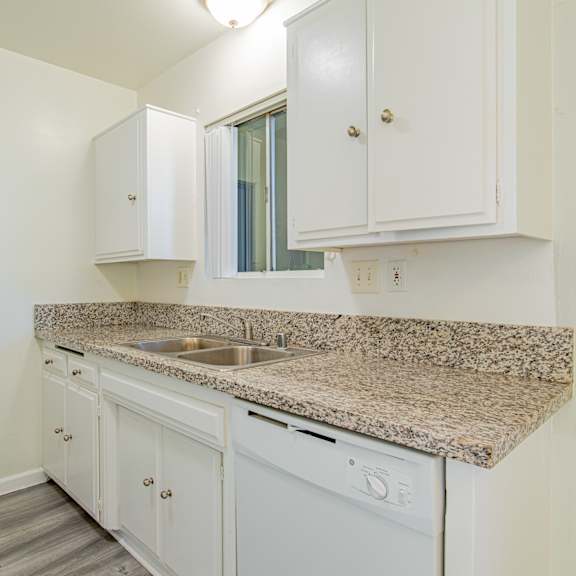 a kitchen with white cabinets and granite counter top and a sink