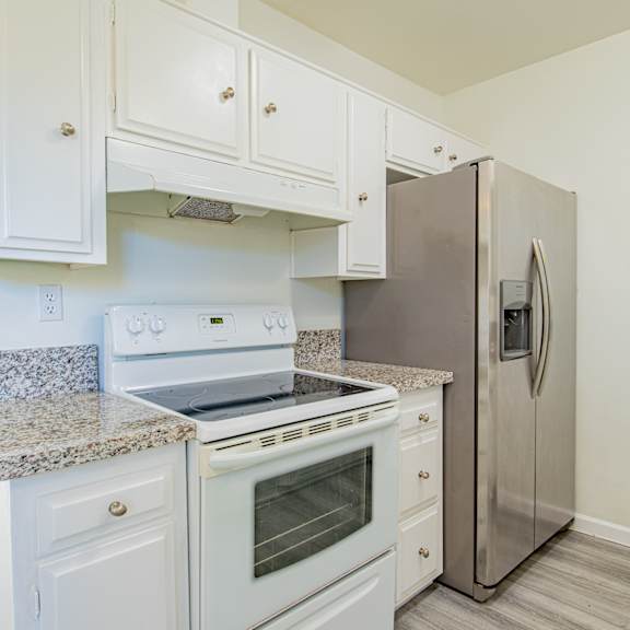 a kitchen with white cabinets and a stainless steel refrigerator
