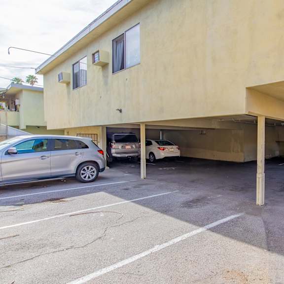 a parking lot with cars parked under a building
