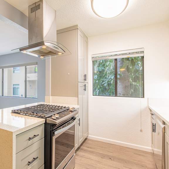 an empty kitchen with a stove and a window