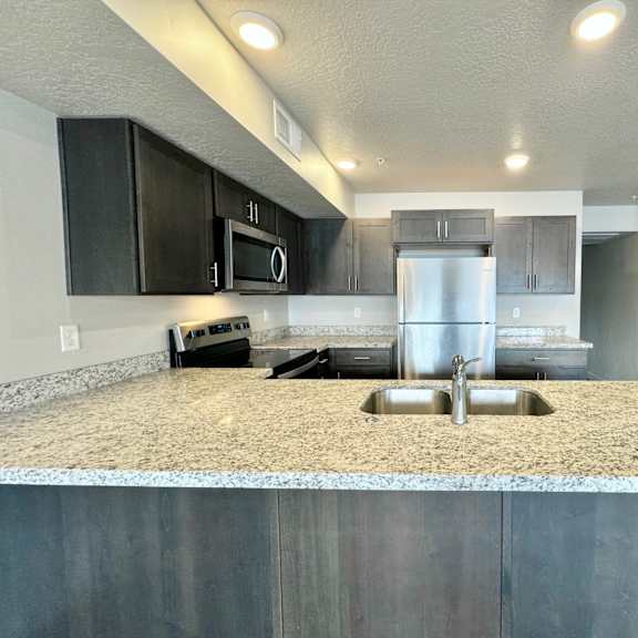 a kitchen with stainless steel appliances and granite counter tops