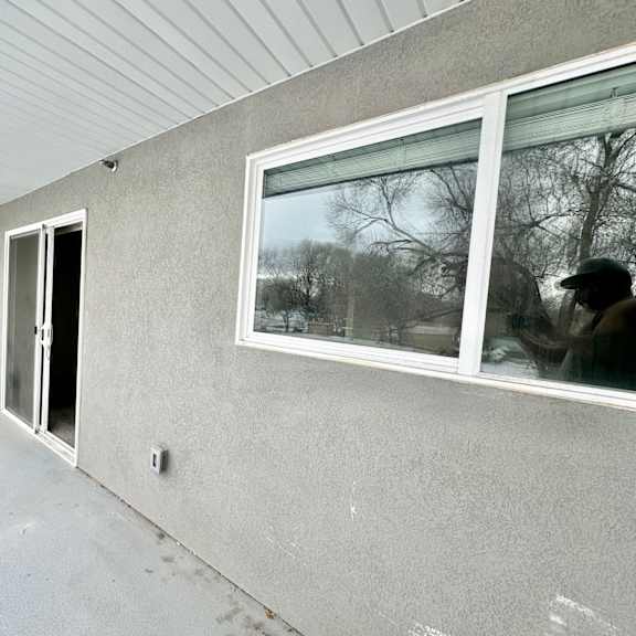 a view of the side of a house with a window and a door