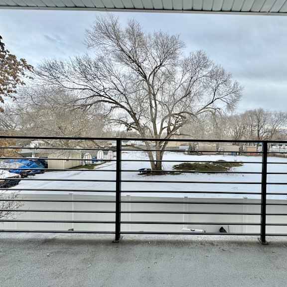 a view of a snow covered parking lot from behind a fence
