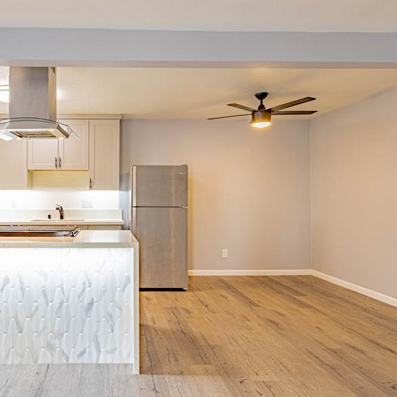 a kitchen with a white counter top and a stainless steel refrigerator