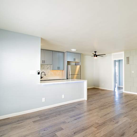 an empty living room with white walls and wood floors