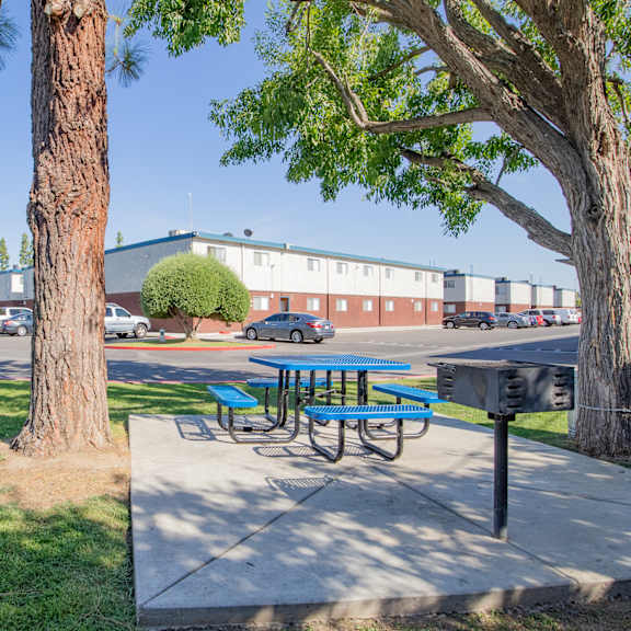 a picnic table on a sidewalk next to a parking lot