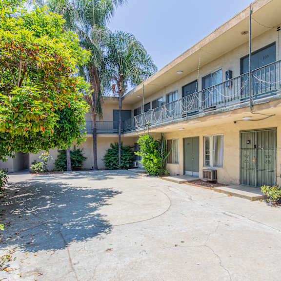 the courtyard of an apartment building with a driveway and a balcony