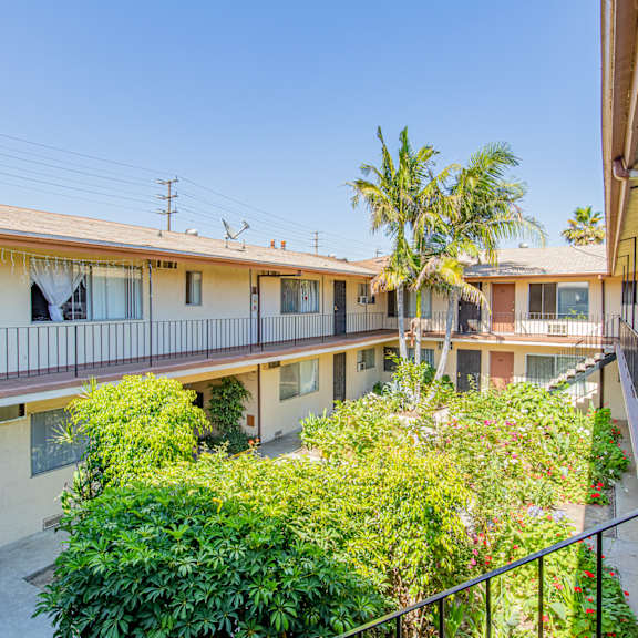 the courtyard of a building with balconies and trees