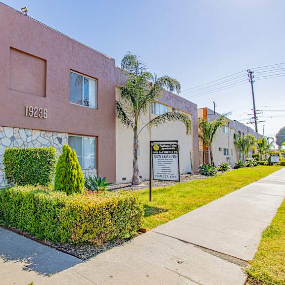 a pink building with a sign on it and a sidewalk