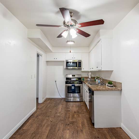 a kitchen with a fan on the ceiling.