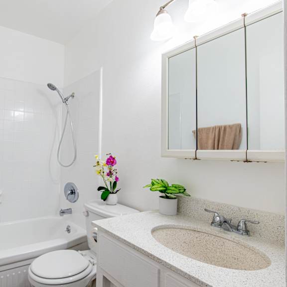 a white bathroom with a towel hanging on the wall.