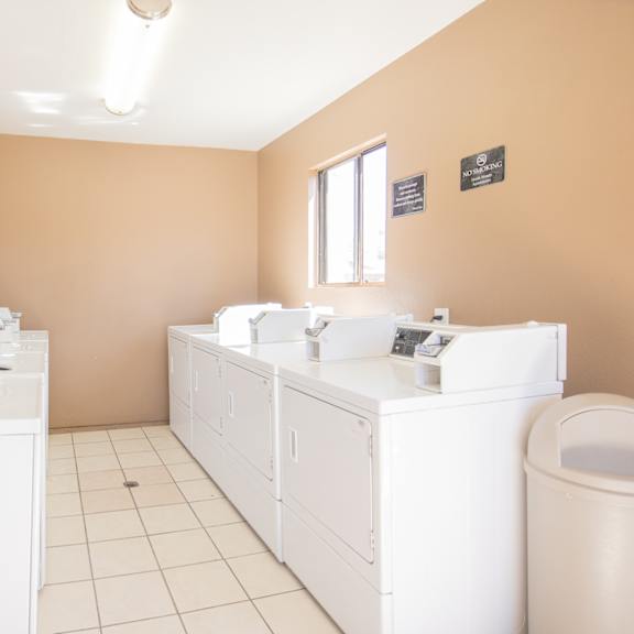 a laundry room with washes and dryers and a toilet