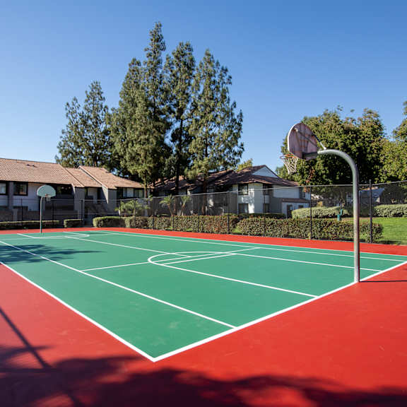 a red and green tennis court with a basketball hoop in the background at metro 3610, riverside, 92505