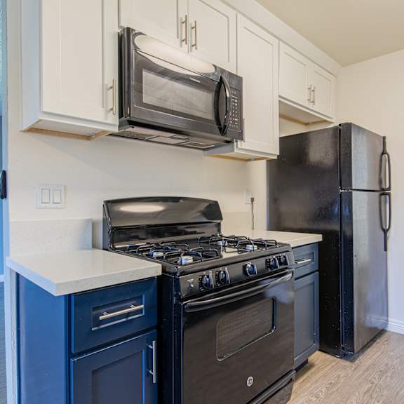 a kitchen with black appliances and white cabinets.
