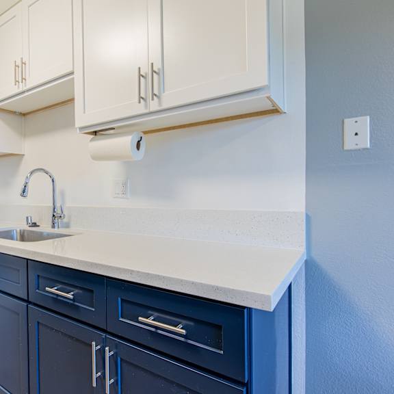 a kitchen with blue cabinets and a white counter.
