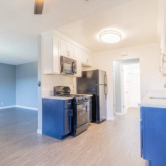 a kitchen with a black stove top oven and black refrigerator.