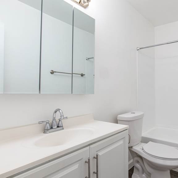 a white bathroom with a toilet, sink, and bathtub.