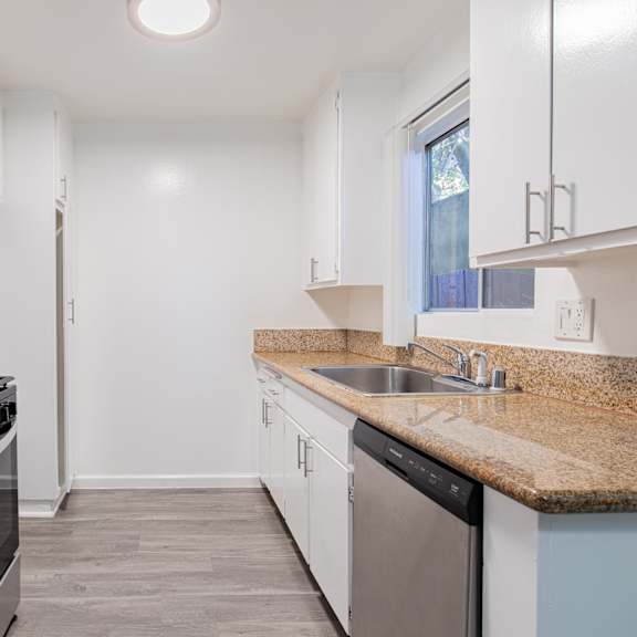 a kitchen with white cabinets and a black stove top oven.
