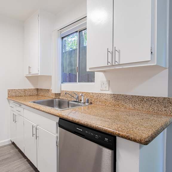 a kitchen with a granite countertop and stainless steel appliances.