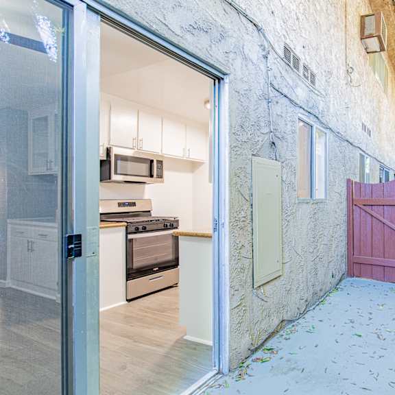 a kitchen with a red gate is visible through an open door.