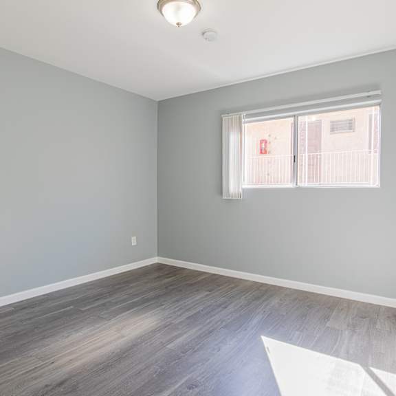 a room with a window and wooden flooring.