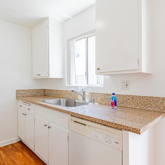 a kitchen with white cabinets and a granite countertop.