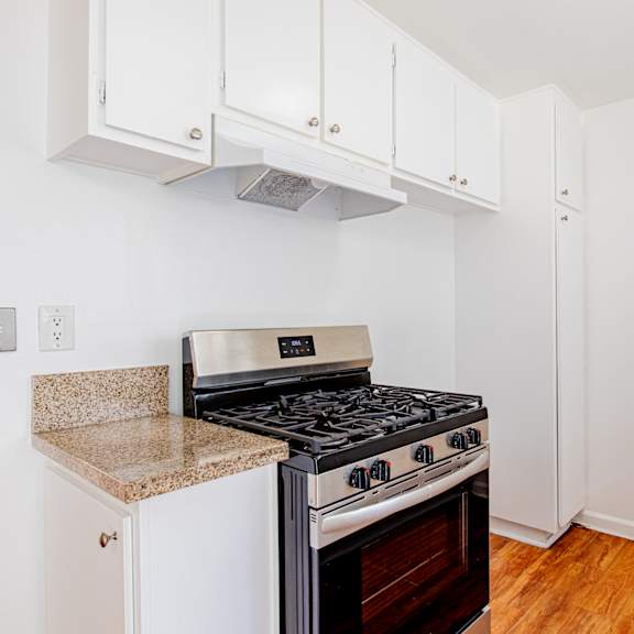 a kitchen with a stove and cabinets.