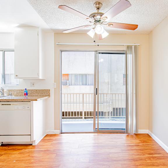 a kitchen with a fan and a view of a balcony.