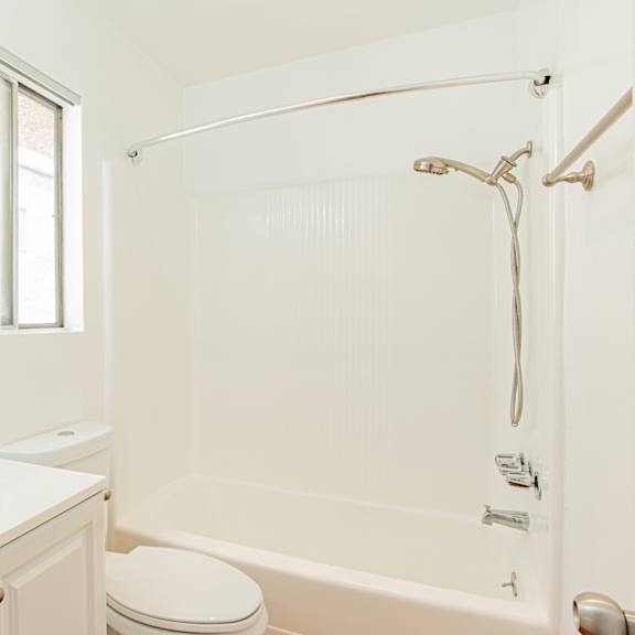 a white bathroom with a toilet, sink, and bathtub.