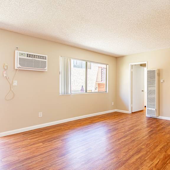 a room with a wood floor and a window.