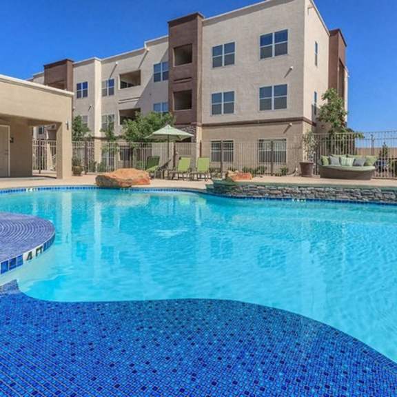 a large swimming pool with an apartment building in the background