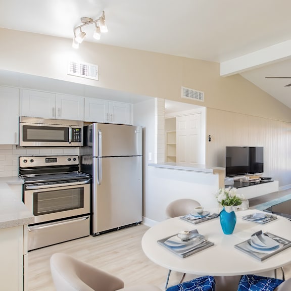 a modern kitchen with a dining area and a living room.