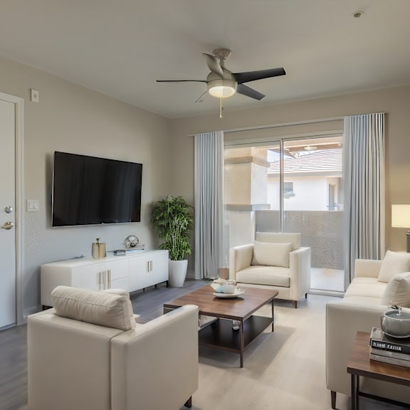 a living room with white furniture and a ceiling fan