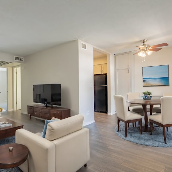 a living room with a television, a dining table, and chairs at sofia apartments, tempe, 85283